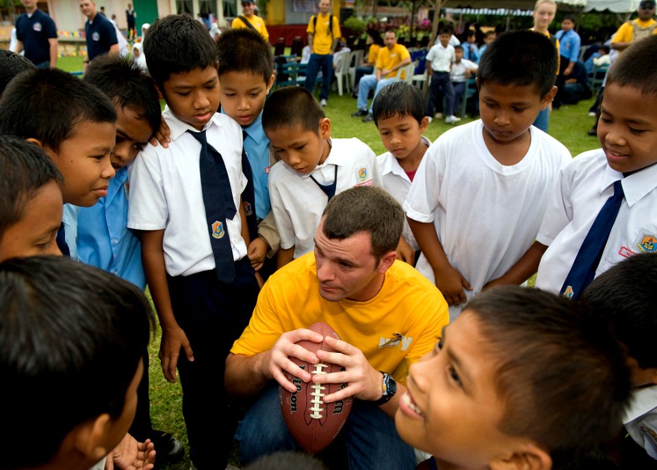 US Navy 090624-N-1722M-483 Fire Controlmen 1st Class Wesley D. Pruitt, assigned to the guided-missile destroyer USS Chung-Hoon (DDG 93), huddles with Malaysian students while playing American football