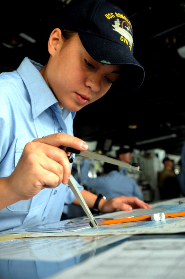 US Navy 090624-N-3610L-388 Quartermaster 3rd Class Melissa Pate uses a compass to plot the movement of the aircraft carrier USS Ronald Reagan (CVN 76) on a navigation chart