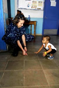 US Navy 090711-F-7923S-188 Hospital Corpsman 2nd Class Beatrice Russell, a medical operations tracker embarked aboard the Military Sealift Command hospital ship USNS Comfort (T-AH 20), plays with a young Nicaraguan boy photo