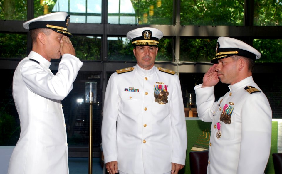 US Navy 090710-N-3090M-100 Rear Adm. Paul Bushong, commander Submarine Group 2, watches on as Capt. Peter Clarke, left, relieves Capt. Emil Casciano, right, as Commander, Submarine Squadron 2, during a change of command ceremon