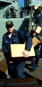 US Navy 090709-N-4879G-270 Quartermaster 2nd Class Matthew Beasley, and other Sailors assigned to the guided-missile frigate USS Doyle (FFG 39), off-load books donated as part of Project Handclasp photo