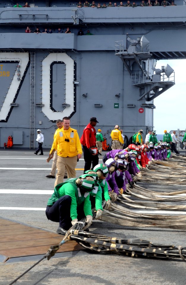 US Navy 090711-N-7456N-006 Chief Aviation Boatswain's Mate (Handling) Benjamin Bilyeu, assigned to the Air department of the aircraft carrier USS Carl Vinson (CVN 70), looks on as Sailors rig the ready jet barricade