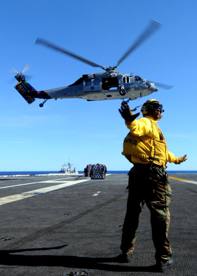 US Navy 090711-N-1062H-037 Aviation Boatswain's Mate (Handling) Airman Jamel Agee directs an MH-60S Sea Hawk helicopter from the Island Knights of Helicopter Combat Squadron (HSC) 25 during a vertical replenishment