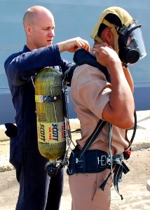 US Navy 090711-N-5207L-102 Damage Controlman Fireman Jason Hazenfield, assigned to the guided-missile frigate USS Crommelin (FFG 37), helps a Royal Thai Navy sailor don a self-contained breathing apparatus (SCBA) during a damag