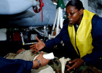US Navy 090712-N-8534H-039 Hospital Corpsman 2nd Class Careese Charles reaches for medical supplies to treat a simulated casualty in the hangar bay aboard USS George Washington (CVN 73) during a mass casualty drill