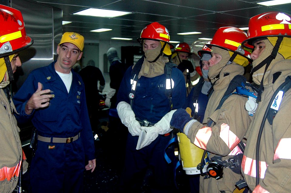 US Navy 090711-N-6410J-044 Chief Aviation Electrician's Mate Michael Dover, a Damage Control Training Team leader aboard the amphibious assault ship USS Boxer (LHD 4), discusses procedures to Sailors during a general quarters d
