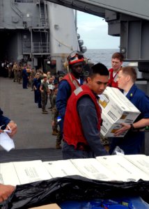 US Navy 090712-N-6692A-115 Sailors and Marines work hand-in-hand to pass supplies for storage during vertical replenishment aboard the forward-deployed amphibious dock landing ship USS Tortuga (LSD 46)