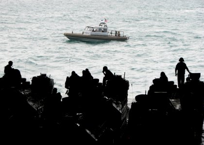 US Navy 090714-N-7058E-001 A safety boat passes off the stern of the dock landing ship USS Harpers Ferry (LSD 49) as U.S. Marines prepare their amphibious assault vehicles for a combined amphibious landing exercise with the Ro