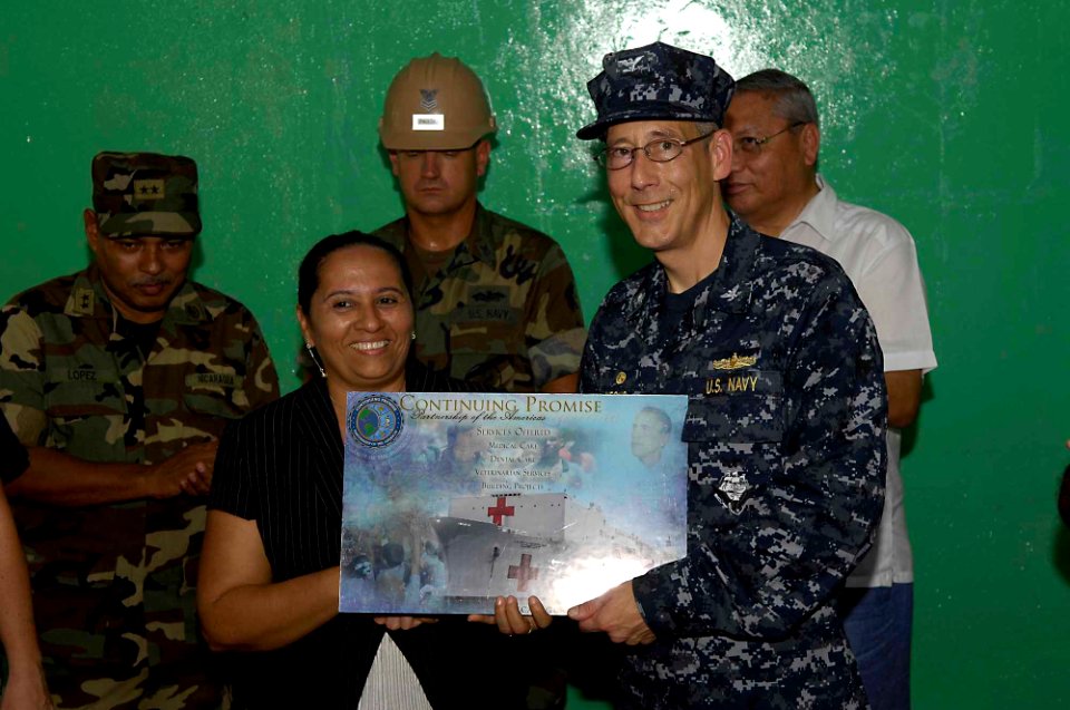 US Navy 090713-F-7923S-232 Capt. Thomas M. Negus, Continuing Promise 2009 mission commander, presents a mission plaque to the principal of the Villanueva School renovated by Construction Battalion Maintenance Unit (CBMU) 202 Se