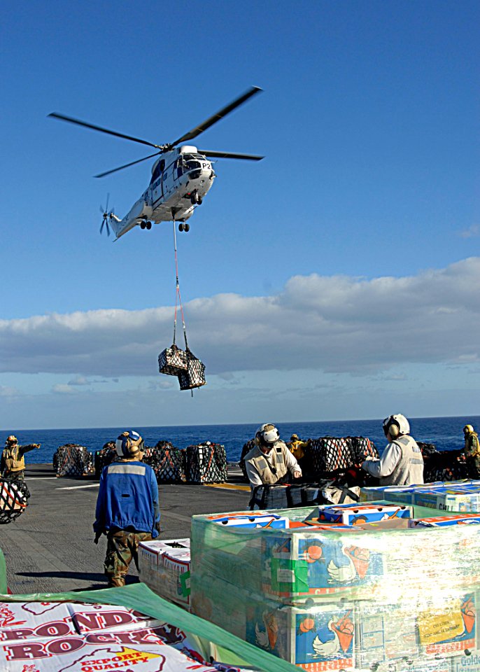 US Navy 090712-N-5215E-076 A AS322 Super Puma dropping off cargo during a vertical replenishment with the Lewis and Clark class dry cargo ship USNS Amelia Earhart (T-AKE 6) aboard the forward deployed amphibious assault ship US
