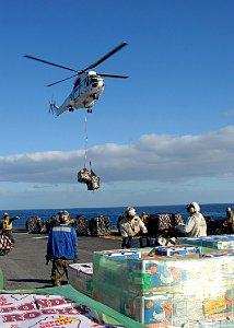 US Navy 090712-N-5215E-076 A AS322 Super Puma dropping off cargo during a vertical replenishment with the Lewis and Clark class dry cargo ship USNS Amelia Earhart (T-AKE 6) aboard the forward deployed amphibious assault ship US