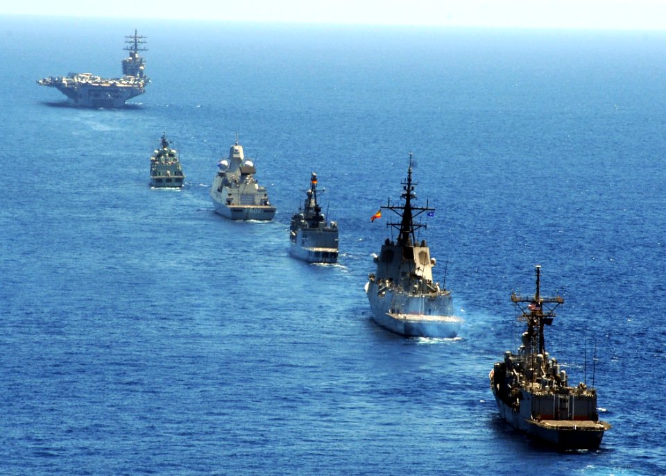 US Navy 090713-N-9988F-203 A multinational formation of ships prepares to come alongside the aircraft carrier USS Dwight D. Eisenhower (CVN 69) during a pass and review exercise during a visit by nearly 100 dignitaries from the