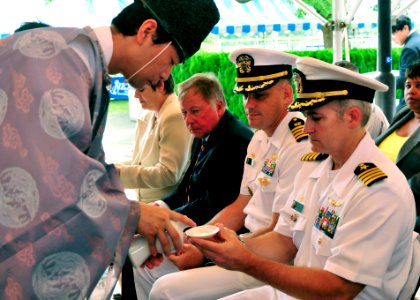 US Navy 090713-N-4031K-001 Commanding Officer Capt. Eric Gardner, Naval Air Facility Atsugi, Japan, accepts sake from a Shinto priest symbolizing the completion of the Navy Exchange expansion project's groundbreaking ceremony