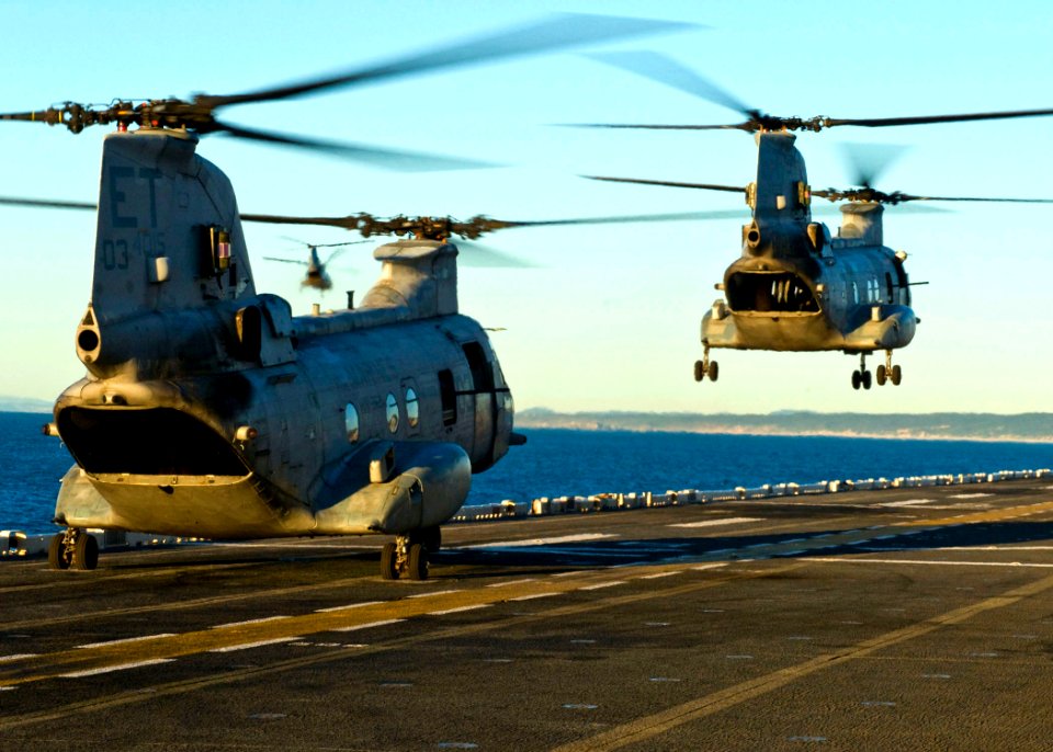 US Navy 090715-N-4010S-126 Two CH-46E Sea Knight helicopters assigned to Marine Medium Helicopter Squadron (HMM) 262 lift off from the amphibious assault ship USS Essex (LHD 2) to support amphibious operations
