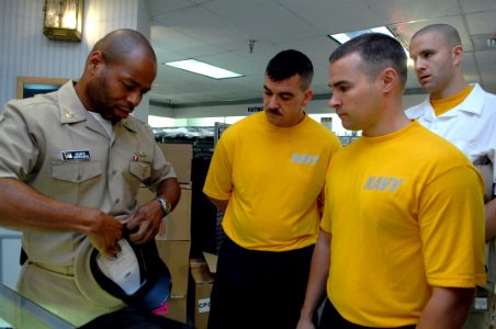 US Navy 090713-N-9818V-083 Master Chief Petty Officer Shawn Newcoste shows the 2009 Sailors of the Year how to put together a chief's combination cover