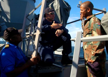 US Navy 090716-N-1655H-150 Lt. Russell Meier, center, weapons officer for USS Arleigh Burke (DDG 51), discusses the capability of the ship's 5-inch gun with South African Navy Lt. Cmdr. Edward Mokoena, left, and South African A