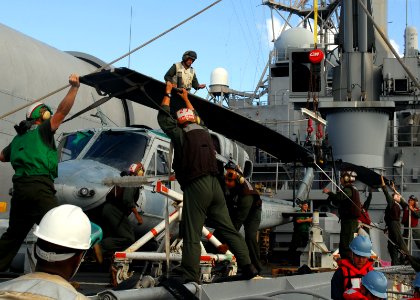 US Navy 090715-N-5538K-143 Sailors assigned to the amphibious transport dock ship USS Denver (LPD 9) remove the rotor blades of an AH-1W Super Cobra helicopter on the flight deck during a Talisman Saber 2009 training exercise