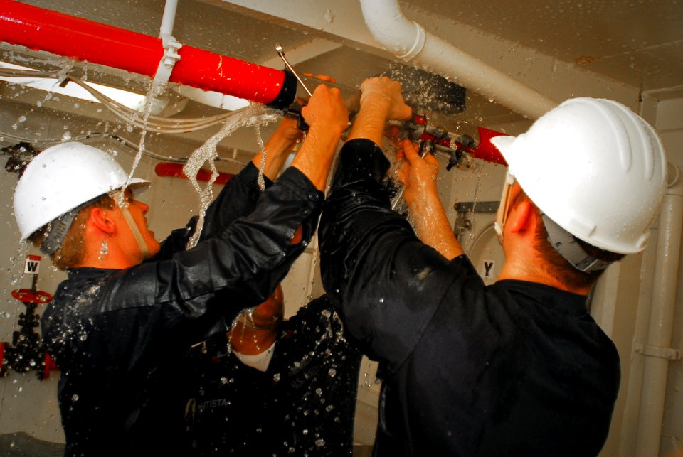 US Navy 090716-N-8590G-008 Members of the damage control team of the guided-missile frigate USS John L. Hall (FFG 32) compete in the pipe-patching event of the Damage Control Olympics