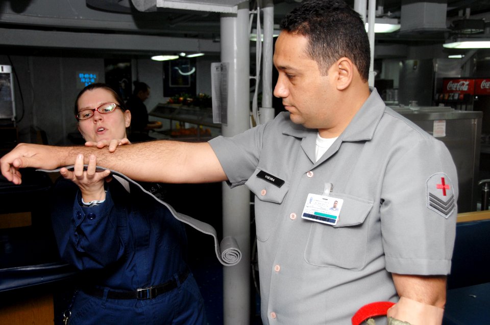 US Navy 090714-A-1839I-038 Hospital Corpsman 1st Class Elizabeth Gracie demonstrates how to apply an arm splint during a first aid class given to Brazilian Navy sailors aboard the amphibious dock landing ship USS Oak Hill (LSD