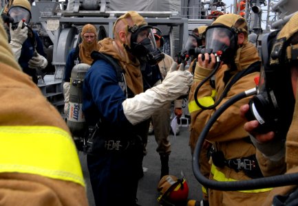 US Navy 090716-N-0807W-182 Sailors assigned to the mine warfare ship USS Avenger (MCM 1) damage control fire party check for a seal on the mask of their self contained breathing apparatus during a main space fire drill