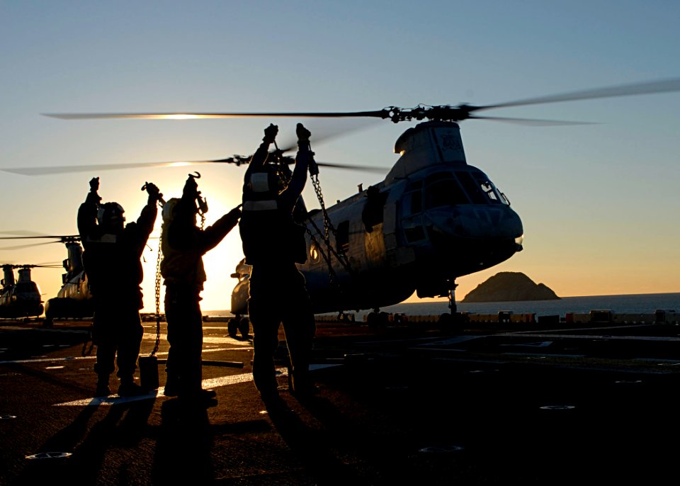 US Navy 090715-N-5215E-124 Aviation Boatswain's Mates (Handling) show their chocks and chains to the pilot of a CH-46E Sea Knight helicopter