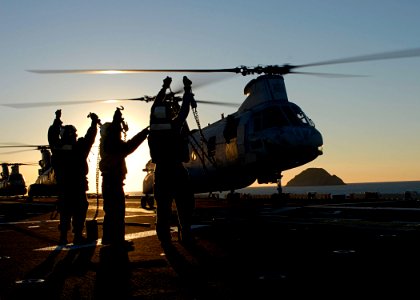 US Navy 090715-N-5215E-124 Aviation Boatswain's Mates (Handling) show their chocks and chains to the pilot of a CH-46E Sea Knight helicopter