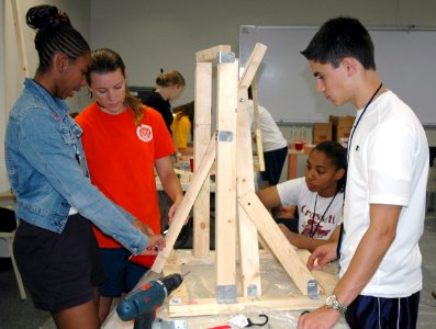 US Navy 090716-N-0437M-042 Navy Junior Reserve Officers Training Corps (NJROTC) Cadet Ensigns, from left, Britany DeFrance, Brooke Zimmerman, Brianca Hollins and James Arnott assemble a wooden catapult for their group project photo