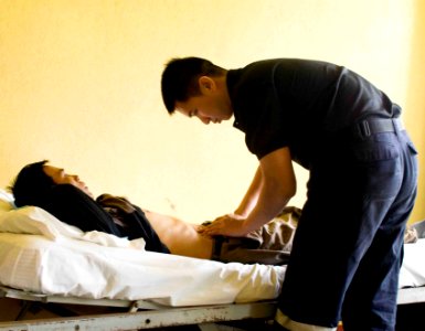 US Navy 090715-N-9689V-008 Republic of Singapore Navy Maj. Boon Hor Ho examines a local man suffering from abdominal pain during a Pacific Partnership 2009 medical civic action project at Niu'ui Hospital