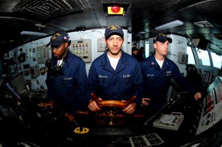 US Navy 090716-N-7456N-032 Boatswain's Mate Seaman Austin Romero, middle, steers USS Carl Vinson (CVN 70) as helmsman while Boatswain's Mate Seaman Reginald Thorton, left, and Boatswain's Mate 2nd Class Jonathan Beesley man the