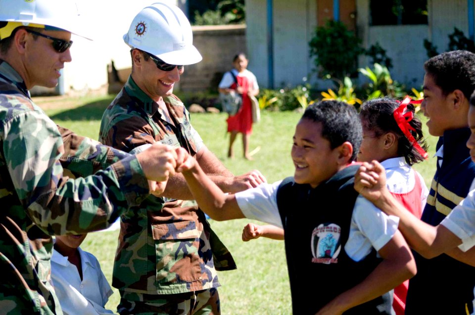US Navy 090717-N-9689V-011 Lt.j.g. Christian Auger of Naval Mobile Construction Battalion (NMCB) 1 and Lt.j.g. Shawn Talley of Amphibious Construction Battalion (ACB) 1 say good-bye to schoolchildren after playing a game of ba
