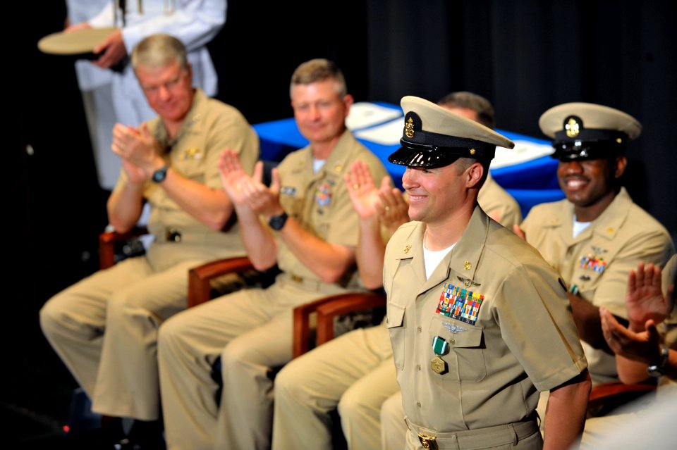US Navy 090716-N-8273J-078 Chief Naval Air Crewman William J. Frost is congratulated by Chief of Naval Operations (CNO) Adm. Gary Roughead, Master Chief Petty Officer of the Navy (MCPON) Rick West and the rest of the audience