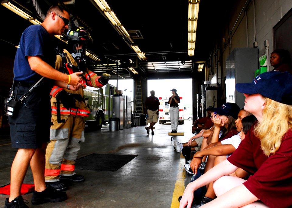 US Navy 090717-N-2456S-002 Firefighters Kris Hudgens, left, and David Fox, both assigned to the Navy Region Mid-Atlantic Fire and Emergency Services, demonstrate the different features of firefighting gear to students