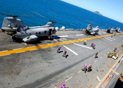 US Navy 090716-N-9950J-199 Sailors rush to refuel a CH-46E Sea Knight helicopter aboard the amphibious assault ship USS Essex (LHD 2) during a mock amphibious assault as part of exercise Talisman Saber 2009 photo
