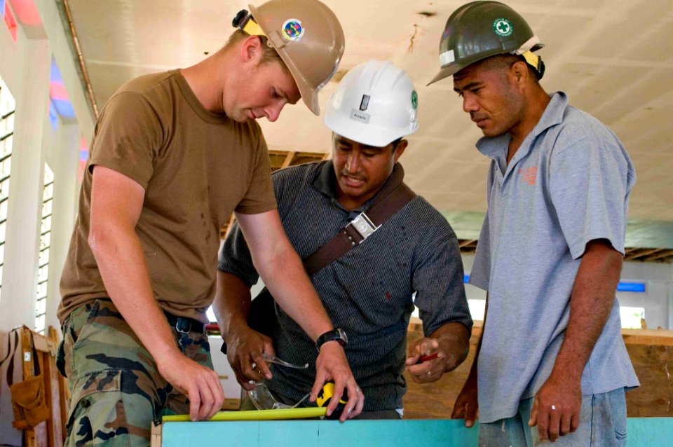 US Navy 090717-N-9689V-002 Builder 2nd Class Mike Howe, assigned to Naval Mobile Construction Battalion (NMCB) 1, works with Toofohe Tuivailala and Saiti Makaafi, local villagers working with NMCB-1, during a Pacific Partnershi