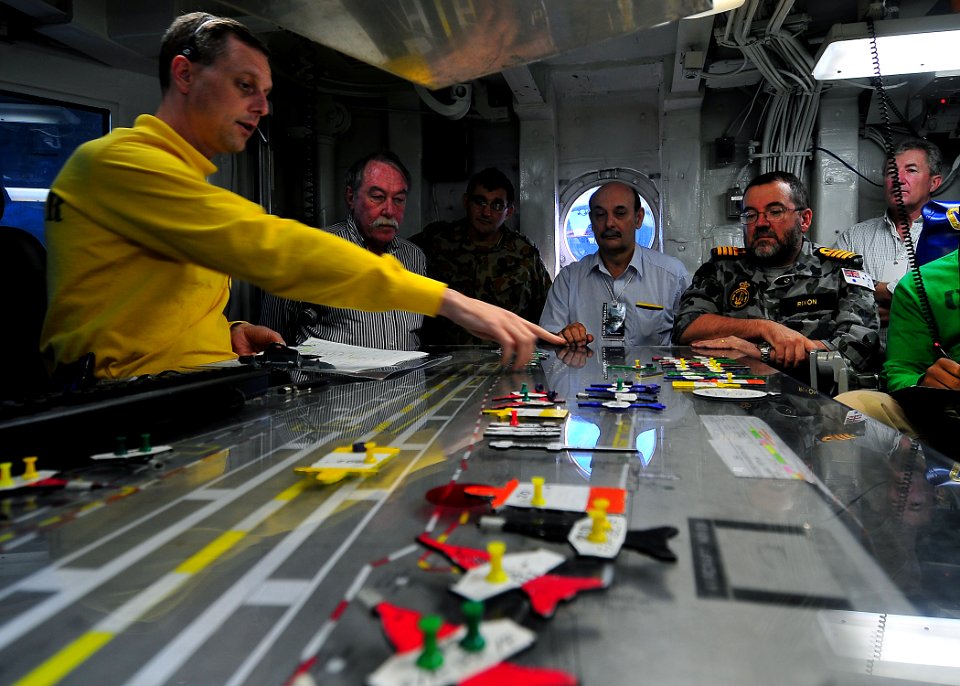 US Navy 090716-N-6233C-155 Lt. Cmdr. Eric Harrington, aircraft handling officer, aboard the aircraft carrier USS George Washington (CVN 73), explains the positioning of planes on the flight deck using the Ouija board