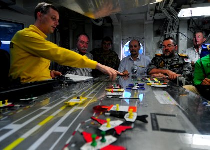 US Navy 090716-N-6233C-155 Lt. Cmdr. Eric Harrington, aircraft handling officer, aboard the aircraft carrier USS George Washington (CVN 73), explains the positioning of planes on the flight deck using the Ouija board
