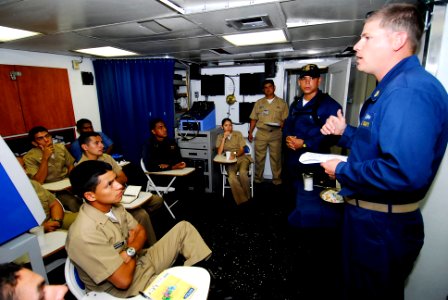 US Navy 090720-N-7092S-397 Chief Gunner's Mate Joshua Tolleson discusses maritime interdiction operation techniques with Colombian sailors during a subject matter expert exchange aboard the guided-missile frigate USS Kauffman (