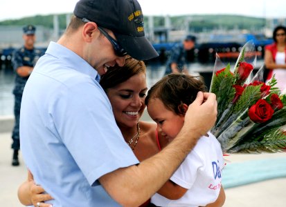 US Navy 090722-N-8467N-005 ulinary Specialist 1st Class Joseph Appold hugs his wife and his 1-year-old son upon the return of the Virginia-class attack submarine USS New Hampshire (SSN 778) to Submarine Base New London