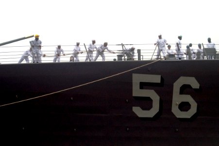 US Navy 090721-N-1251W-005 Sailors assigned to deck department aboard the guided-missile destroyer USS John S. McCain (DDG 56) slacks out line while mooring to Osanbashi Pier in the Port of Yokohama
