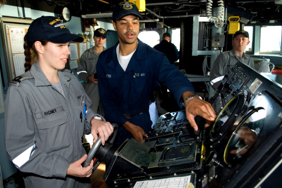 US Navy 090720-N-9123L-033 Seaman Michael Dokter, from Seattle Wash., explains functions of the helm of the guided-missile destroyer USS McCampbell (DDG 85) to Royal Australian Navy Sublieutenant Stacey Rigney