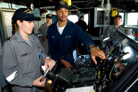 US Navy 090720-N-9123L-033 Seaman Michael Dokter, from Seattle Wash., explains functions of the helm of the guided-missile destroyer USS McCampbell (DDG 85) to Royal Australian Navy Sublieutenant Stacey Rigney