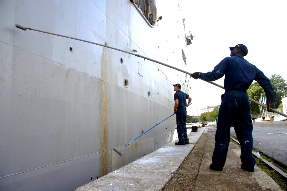 US Navy 090721-A-1839I-013 Boatswains Mate Seaman Pascal Koffi and Seaman David Westbrook, both assigned to the amphibious dock landing ship USS Oak Hill (LSD 51), paint the side of the ship during a port visit to Rio De Janeir