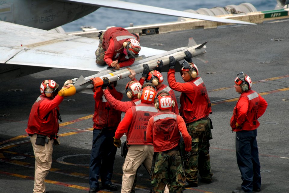 US Navy 090720-N-9132C-115 Aviation ordnancemen assigned to Strike Fighter Squadron (VFA) 25 detach an AIM-9 Sidewinder missile from the wing of an F-A-18C Hornet aboard the aircraft carrier USS Ronald Reagan (CVN 76)