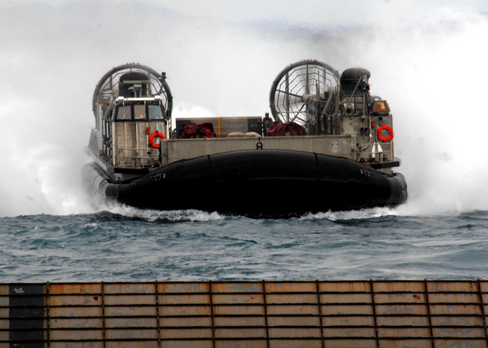 US Navy 090721-N-6692A-033 Landing Craft Air Cushion (LCAC) 8 launched from the Navy's forward-deployed amphibious assault ship USS Essex (LHD 2), prepares to enter the well deck of amphibious dock landing ship USS Tortuga (LSD