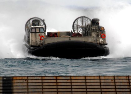 US Navy 090721-N-6692A-033 Landing Craft Air Cushion (LCAC) 8 launched from the Navy's forward-deployed amphibious assault ship USS Essex (LHD 2), prepares to enter the well deck of amphibious dock landing ship USS Tortuga (LSD