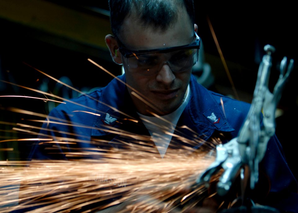 US Navy 090721-N-9520G-068 Hull Maintenance Technician 3rd Class Aaron Thomasson, from Little Rock, Ark. assigned to the amphibious assault ship USS Essex (LHD 2), uses a grinder to smooth out a metal lettering project