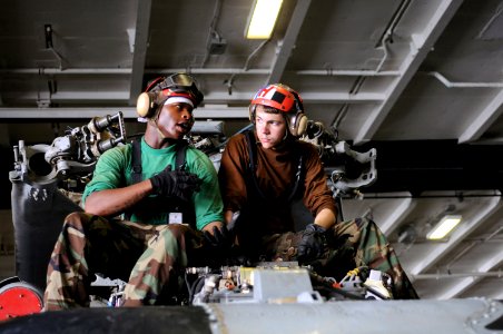 US Navy 090722-N-2344B-058 Aviation Machinist's Mate Airman Apprentice James Fuller and Aviation Structural Mechanic Airman Ryan Safarik discuss a turn around inspection they are performing on an SH-60F Sea Hawk helicopter