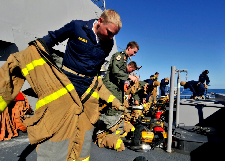 US Navy 090723-N-2638R-003 U.S. and Australian midshipmen aboard Arleigh Burke-class guided-missile destroyer USS Mustin (DDG 89) race to properly don their fire fighting gear