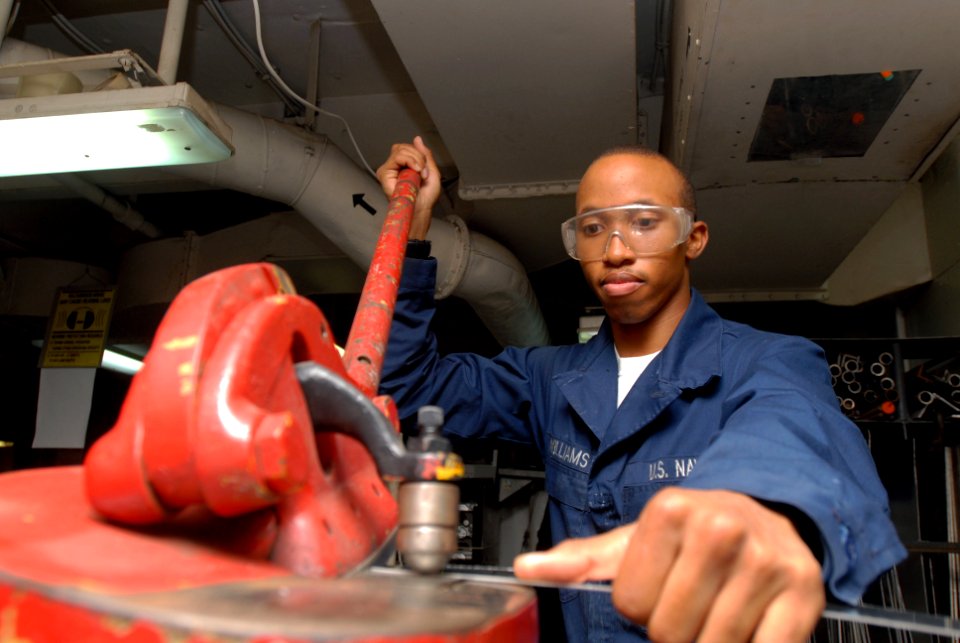 US Navy 090723-N-2918M-003 Aviation Structural Mechanic Airman Jeremy Williams uses a throat-less sheer to cut scrap metal in the Airframe shop aboard the aircraft carrier USS Nimitz (CVN 68)