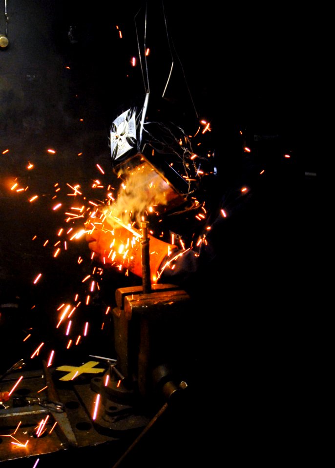 US Navy 090725-N-2600H-045 Hull Technician 3rd Class Michael Kilpatrick welds a bolt to a pipe aboard the aircraft carrier USS Nimitz (CVN 68)